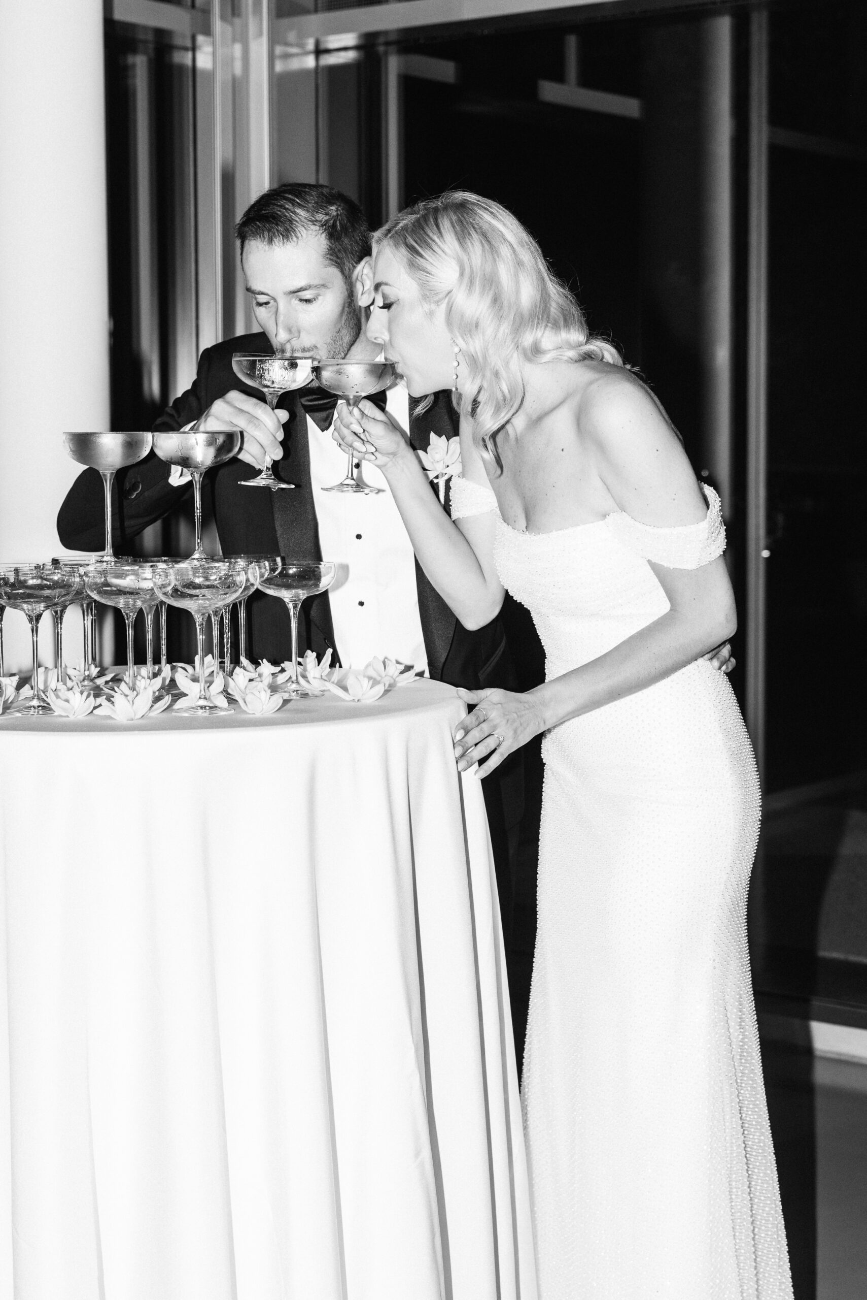 Black and white photo of Bride and Groom with Champagne Tower, at Art Galley of Hamilton wedding photographed by Jenn Kavanagh Photography